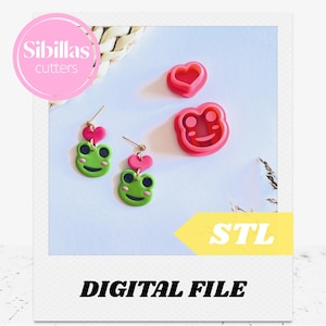 May include: A pair of green frog earrings with pink heart accents and two pink frog-shaped cookie cutters. The image also includes a pink circle with the text "Sibillas cutters" and a yellow arrow with the text "STL". The words "DIGITAL FILE" are also present.