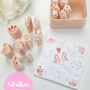 A close-up image of a Nordic floral stamp for polymer clay, showcasing the engraved design inspired by Scandinavian folk art. The deep relief allows for crisp impressions in clay, perfect for use in DIY jewelry, crafts, and handmade accessories. The material is durable and lightweight, and the carving shows heart and flower shapes common in traditional folk motifs. This stamp is ideal for makers who love boho, vintage, and Nordic aesthetic details in their creations.