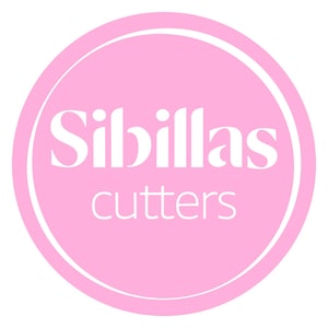 May include: A circular logo with a pink background and a white border. The text "Sibillas" is in a large, elegant font above the word "cutters" in a smaller, sans-serif font, both in white.
