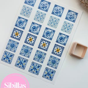 Peut inclure: Une feuille d'autocollants carrés présentant divers motifs de carreaux floraux bleus et blancs avec des accents jaunes occasionnels, accompagnée d'un emporte-pièce carré en plastique beige. Les motifs affichent des détails botaniques.