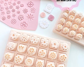May include: Light pink plastic flower-shaped clay cutters arranged in grids on rectangular trays. A pink clay sheet shows impressed floral patterns. Text reads: 3 sizes: 10 mm (0.4 In), 15 mm (0.6 In), 20 mm (0.8 In) and Sibillas cutters.