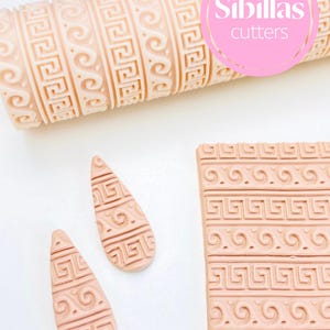 Ancient Greek pattern roller for polymer clay, ceramics, and pottery crafts. The roller creates finely detailed classical motifs reminiscent of traditional Greek art and architecture. Ideal for earrings, pendants, pottery surfaces, and home décor projects, this embossing tool is reusable and made for precision. It allows makers to add a timeless, ornamental look to their clay creations, perfect for DIY crafters, jewelry makers, and ceramic artists seeking elegant, historical designs.