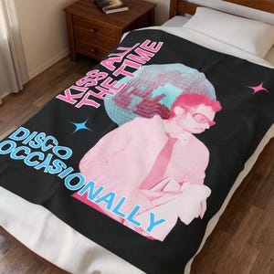 May include: Black blanket with a retro disco theme. The blanket features a pink and blue graphic of a person wearing sunglasses, a disco ball, and the text "KISS ALL THE TIME" and "DISCO OCCASIONALLY".