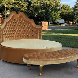 May include: A round, tufted bed frame with a matching tufted ottoman. The bed frame and ottoman are upholstered in a gold velvet fabric.