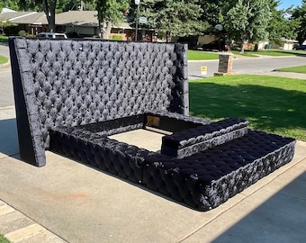 May include: A black velvet tufted headboard with a matching tufted platform bed frame. The headboard is tall and has a wingback design. The platform bed frame has a built-in bench at the foot of the bed.