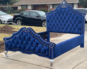 May include: A blue velvet headboard with a tufted design and silver accents. The headboard has a crown-shaped top and is upholstered in a soft, luxurious fabric.