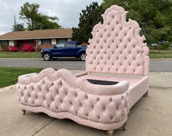May include: A pink tufted headboard with a matching tufted footboard. The headboard is tall and ornate with a scalloped top. The footboard is lower and has a more simple design.