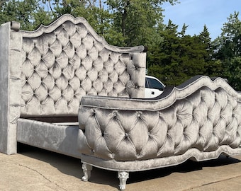 May include: A gray tufted velvet headboard with a curved design and silver-toned feet. The headboard is upholstered in a soft, luxurious fabric and features a tufted design.