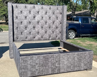 May include: A gray upholstered bed frame with a tall headboard featuring a diamond tufted design. The headboard is tall and has a wingback style.