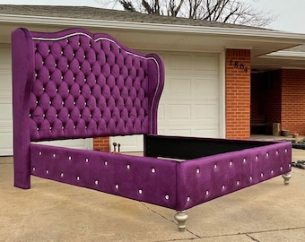 May include: A purple velvet tufted headboard with a diamond pattern and crystal accents. The headboard is attached to a matching footboard and frame.
