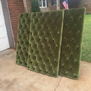 Puede incluir: Tres paneles de cabecero de terciopelo verde con capiton&eacute; en forma de diamante. Los paneles est&aacute;n dispuestos verticalmente y se apoyan contra una pared de ladrillo.