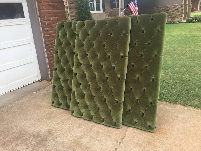Puede incluir: Tres paneles de cabecero de terciopelo verde con capiton&eacute; en forma de diamante. Los paneles est&aacute;n dispuestos verticalmente y se apoyan contra una pared de ladrillo.