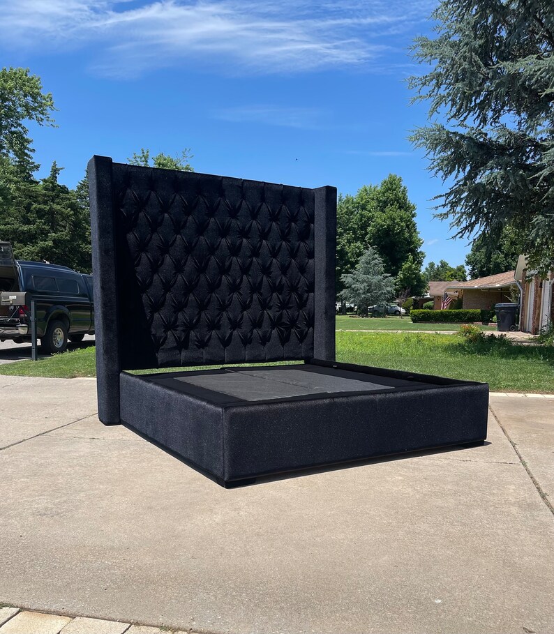 May include: A black upholstered bed frame with a tall headboard featuring a tufted design. The headboard is tall and has a square shape.