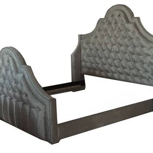 K&ouml;nnte beinhalten: Ein graues, gepolstertes Bettgestell mit einem gesteppten Kopfteil und einem geschwungenen Design. Das Kopfteil hat ein Rautenmuster und ist mit kleinen, klaren Kristallen verziert.