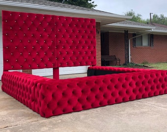 May include: A large, red velvet bed frame with a tufted headboard and matching footboard. The headboard is tall and features a diamond-shaped pattern with crystal-like buttons.
