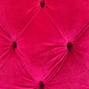 Puede incluir: Primer plano de una tela de terciopelo rosa oscuro con cuatro botones. La tela tiene un patr&oacute;n de diamante.