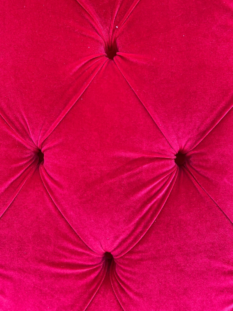 Puede incluir: Primer plano de una tela de terciopelo rosa oscuro con cuatro botones. La tela tiene un patr&oacute;n de diamante.