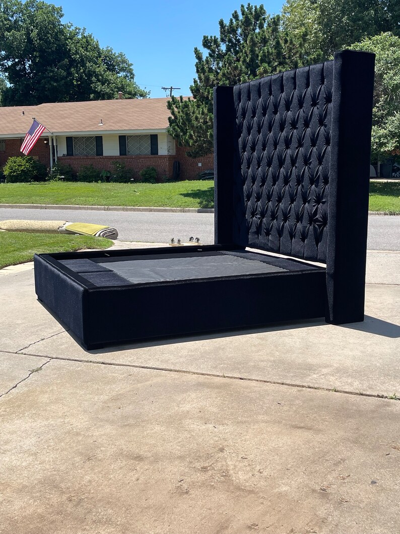 May include: A black upholstered bed frame with a tall, tufted headboard. The headboard has a diamond pattern and is very tall.