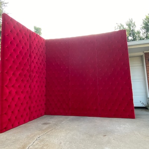 Puede incluir: Un gran panel de pared rojo capiton&eacute; hecho de tela. El panel est&aacute; formado por tres secciones y est&aacute; de pie en una entrada de veh&iacute;culos.