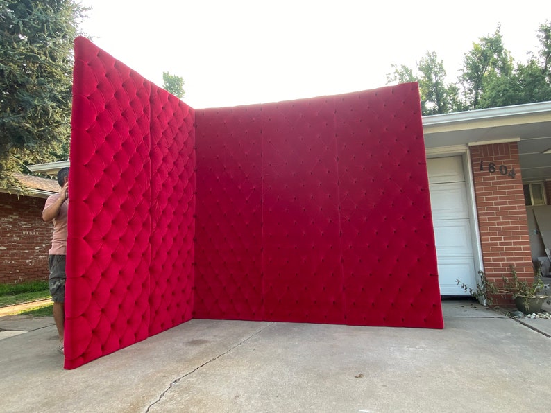 Puede incluir: Un gran panel de pared rojo capiton&eacute; hecho de tela. El panel est&aacute; formado por tres secciones y est&aacute; de pie en una entrada de veh&iacute;culos.