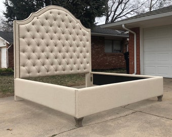 May include: A tufted headboard with a curved top and a beige linen fabric. The headboard is attached to a matching beige linen bed frame.