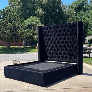 May include: A black upholstered bed frame with a tall headboard featuring a tufted design. The headboard is tall and has a square shape.