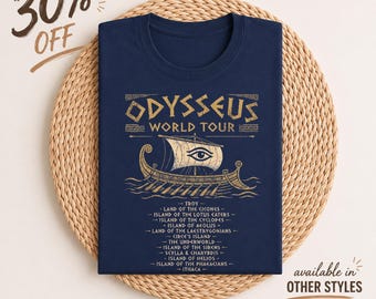 Puede incluir: Una camiseta azul marino con un gráfico dorado de un barco con un ojo en la vela. El texto dice Odysseus World Tour seguido de una lista de lugares que incluye Troy, Land of the Cicones, Island of the Lotus Eaters e Island of the Cyclopes.