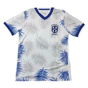 Puede incluir: Camiseta de fútbol de Brasil blanca y azul con cuello en V y mangas cortas. La camiseta presenta un estampado de hojas de palmera grises y detalles azules en las mangas y el cuello. El escudo y el texto de Brasil están en el pecho.