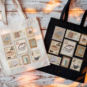 K&ouml;nnte beinhalten: Zwei Tragetaschen, eine cremefarbene und eine schwarze, jeweils mit einer Collage aus Briefmarkenmotiven. Die Briefmarken zeigen B&uuml;cherstapel, Kaffeetassen und andere Illustrationen zum Thema B&uuml;cher. Die Taschen haben lange Henkel.