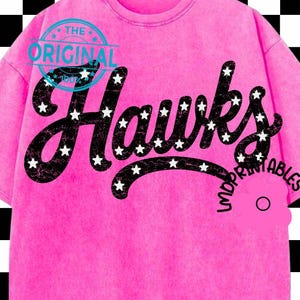 May include: A bright pink short-sleeve t-shirt featuring the word Hawks in large black script lettering filled with small white stars. The text The Original is printed in blue above the word Hawks, and LMDPRINTABLES is printed in black.