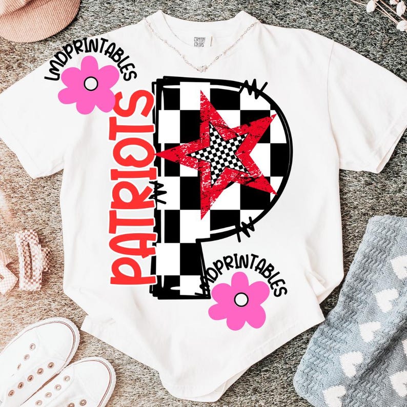 K&ouml;nnte beinhalten: Wei&szlig;es T-Shirt mit einem gro&szlig;en roten Stern &uuml;ber einem schwarz-wei&szlig;en Schachbrettmuster. Das Wort "PATRIOTS" ist vertikal in Rot gedruckt. Rosa Blumen und das Wort "LMDPRINTABLES" sind ebenfalls auf dem Shirt aufgedruckt.
