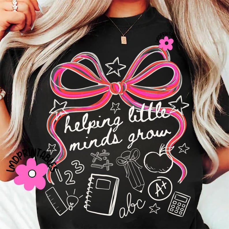 May include: Black t-shirt with a large pink and red bow design and the words "helping little minds grow." White illustrations of stars, an apple, a notebook, and other school-related items are also featured.