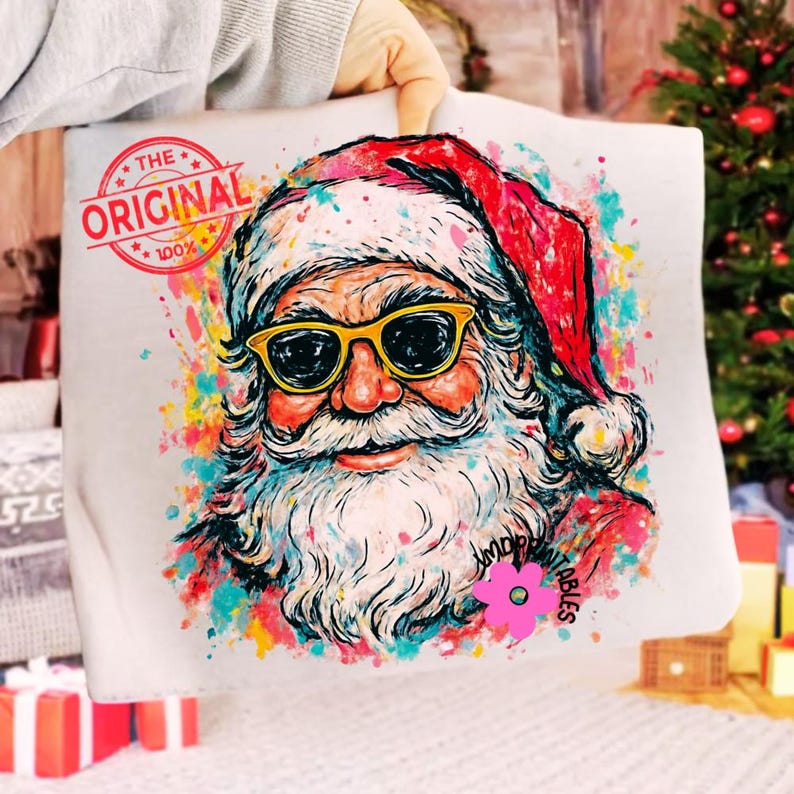 May include: A white tote bag with a vibrant illustration of Santa Claus sporting sunglasses. The design includes the text "THE ORIGINAL 100%" in a red stamp. Santa is depicted with a white beard and a red hat.