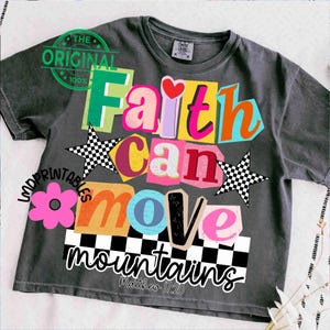 May include: Dark gray t-shirt with a colorful graphic design. The design features the words "Faith Can Move Mountains" in various bright colors and fonts, along with a pink flower, checkered stars, and the text "Matthew 17:20".