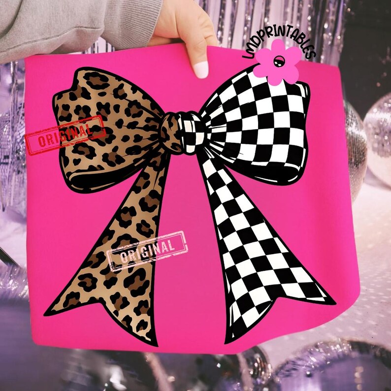 May include: A hot pink tote bag featuring a large bow design. One side of the bow has a leopard print pattern, while the other side has a black and white checkered pattern. The word "ORIGINAL" is stamped on the bag.