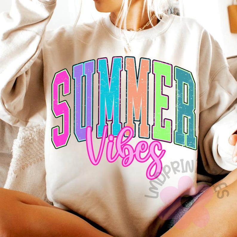Puede incluir: Sudadera color crema con las palabras "SUMMER Vibes" en una fuente universitaria colorida y desgastada. La palabra "SUMMER" est&aacute; en un estilo de letras en bloque en negrita con un degradado de rosa, azul, naranja y verde. La palabra "Vibes" est&aacute; en cursiva rosa.