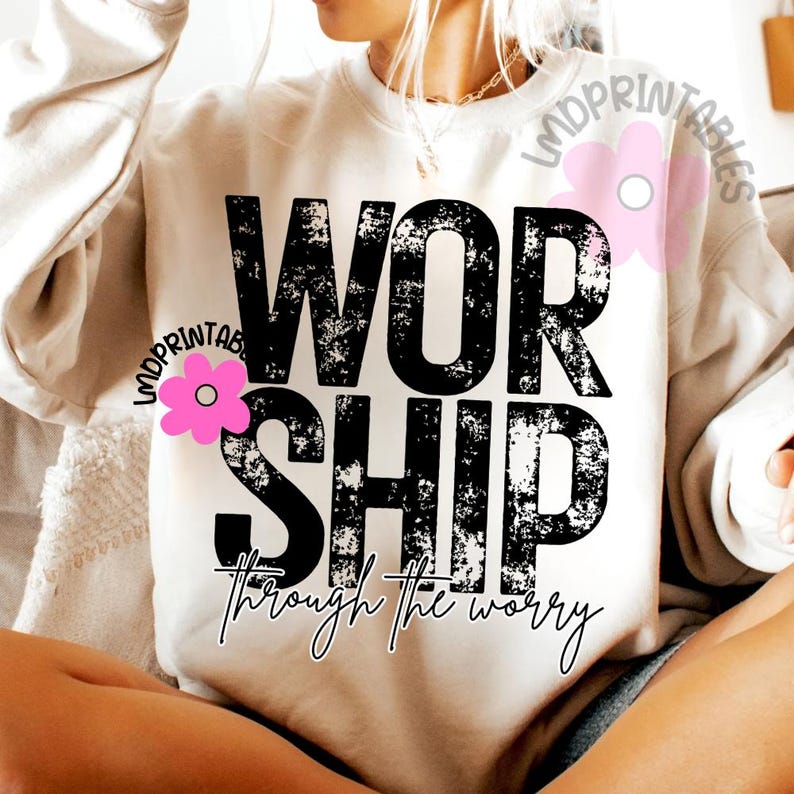Pu&ograve; includere: Felpa color crema con la parola "WORSHIP" in grandi lettere nere consumate. Sotto, la frase "through the worry" &egrave; scritta in corsivo. Una grafica floreale rosa &egrave; sul lato sinistro.