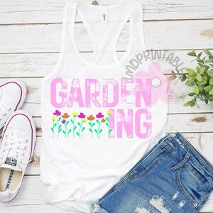 May include: White tank top with the word "GARDENING" in pink, with colorful flower graphics. The tank top is paired with denim shorts and white sneakers, suggesting a casual, gardening-themed outfit.