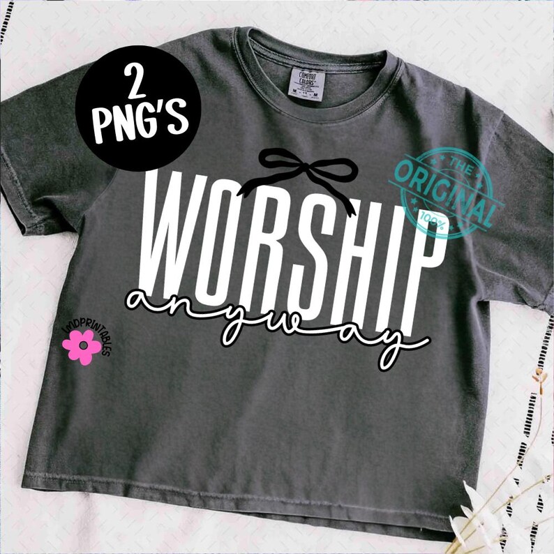 May include: Dark grey t-shirt with the words "WORSHIP anyway" in white and black script. A black bow is above the word "WORSHIP". A pink flower graphic is in the lower left corner. A black circle with the words "2 PNG'S" is in the upper left corner.