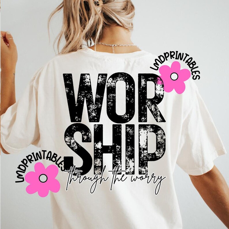 Pu&ograve; includere: T-shirt color crema con la parola "WORSHIP" in grandi lettere nere consumate. Sotto, la frase "through the worry" &egrave; scritta in un carattere script. Grafiche di fiori rosa con il testo "LMDPRINTABLES" sono sulla maglietta.