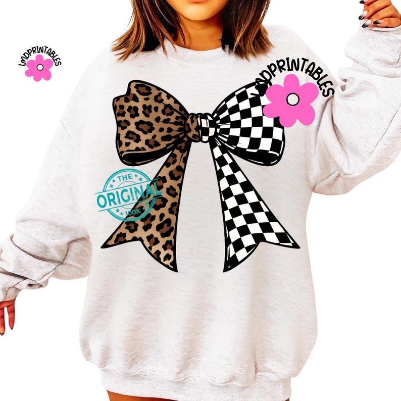 May include: A light gray sweatshirt featuring a large bow design. The bow is split, with a leopard print on one side and a black and white checkered pattern on the other. The text "THE ORIGINAL 100%" is also visible.