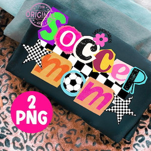 May include: Dark teal t-shirt with a colorful "Soccer Mom" graphic. The design includes a soccer ball, stars, and the text "2 PNG". The shirt is folded on a leopard print surface.