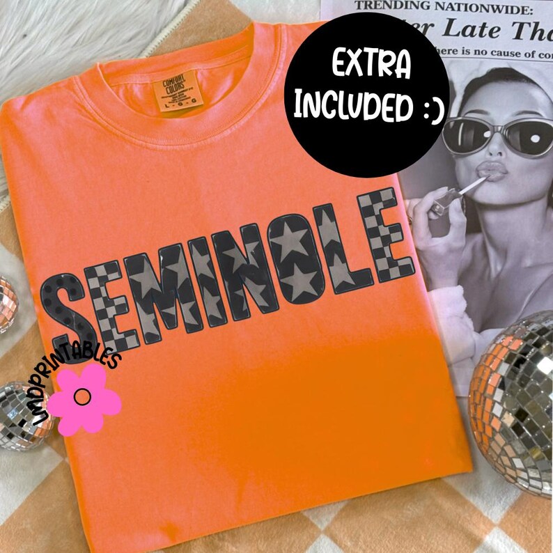 May include: Bright orange t-shirt with the word "SEMINOLE" in gray star and checkered patterns. The shirt has a crew neck and short sleeves. A black circle with the text "EXTRA INCLUDED :)" is in the background.