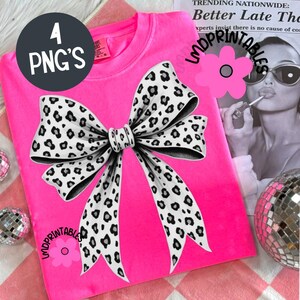 May include: A bright pink t-shirt featuring a large bow design with a black and white leopard print. The text "4 PNG'S" is in a black circle in the upper left corner. The text "LMDPRINTABLES" is in pink cursive on the shirt.