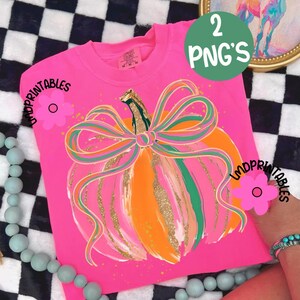 Peut inclure: Un t-shirt rose vif &agrave; manches longues avec un motif de citrouille color&eacute;. La citrouille est orange et rose avec un n&oelig;ud vert et dor&eacute;. Le texte "2 PNG's" est dans un cercle vert. Le t-shirt porte le texte "LMDPRINTABLES".