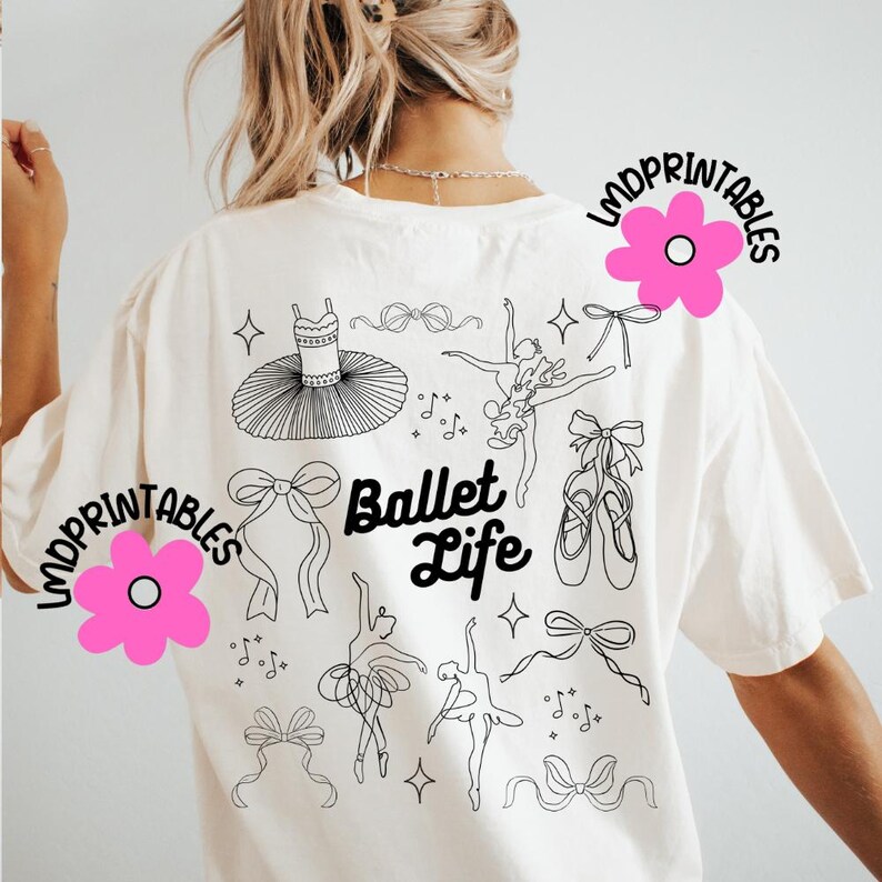 May include: Cream-colored t-shirt featuring a black line art design of ballet-themed elements. The design includes a tutu, ballet shoes, bows, dancers, and musical notes. The words "Ballet Life" are also printed on the shirt.