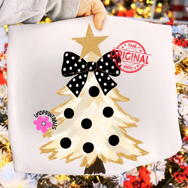 May include: A white Christmas-themed design featuring a stylized tree with gold accents, black polka dots, and a black and white polka dot bow. A gold star tops the tree. The text "THE ORIGINAL 100%" is stamped in red.