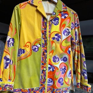 Op de afbeelding: Een lang mouw overhemd met knopen en een psychedelisch patroon in tinten van groen, geel, oranje, paars en wit. Het overhemd heeft een kraag en een knoopsluiting.