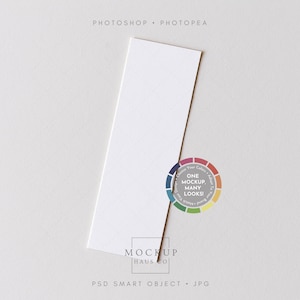 May include: A white rectangular card with a subtle grid pattern, set diagonally on a light grey surface. A colour wheel graphic with the text "One Mockup, Many Looks!" and the Mockup Haus Co. logo are also visible.
