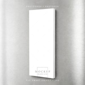 Puede incluir: Maqueta de producto rectangular blanca con un patrón de diamantes, adherida a una superficie de metal cepillado. El texto "MOCKUP HAUS CO" es visible en la parte inferior, junto con "PSD SMART OBJECT . JPG" y "PHOTOSHOP . PHOTOPEA".